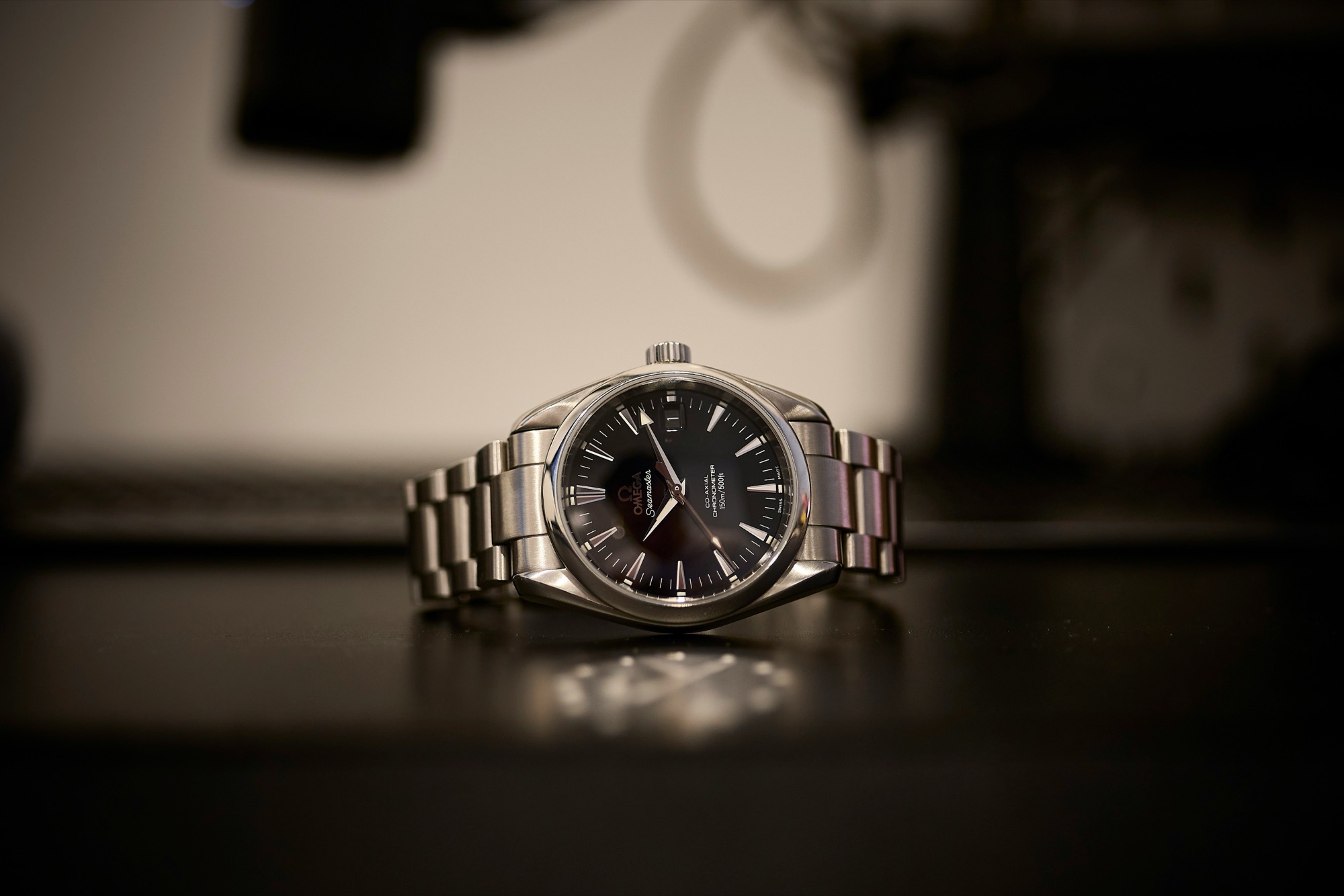 Steel luxury watch standing on a desk